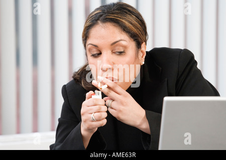 Vue d'une businesswoman de fumer dans le bureau. Banque D'Images