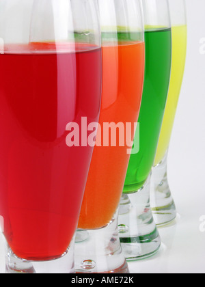 Quatre verres de boisson Kool Aid Koolaid versé dans une boisson en verre personne sur fond de table blanc gros plan vue avant remplissage fond haute résolution Banque D'Images