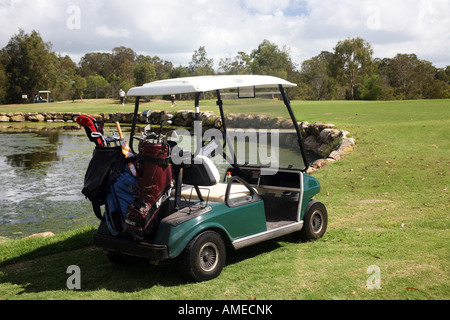 Chariot de golf sur un terrain de golf à côté d'un lac Banque D'Images