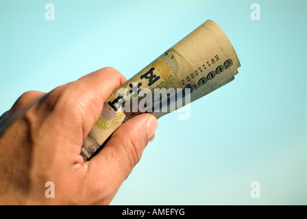 Close-up of a hand holding Yen billets de banque (monnaie japonaise) Banque D'Images