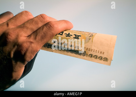 Close-up of a hand holding Yen billets de banque (monnaie japonaise) Banque D'Images