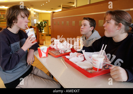 Les adolescents à manger un fast-food restaurant Banque D'Images