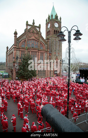 Plus de 10 000 personnes habillées en père Noël tenter le record mondial Guinness dans guildhall square avec cannon Derry Banque D'Images