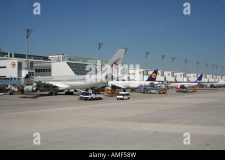 Aéroport et avions. Avions à leurs portes à l'aéroport de Munich, Allemagne. Un Airbus A330 de Qatar Airways est au premier plan. Voyage aérien. Banque D'Images