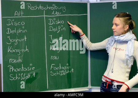 Une fille a écrit des mots allemands selon de nouvelles règles d'orthographe sur le conseil à l'école Banque D'Images