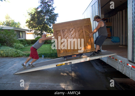 Movers pousser un piano sur une rampe dans le camion de déménagement à Boise, Idaho. Banque D'Images