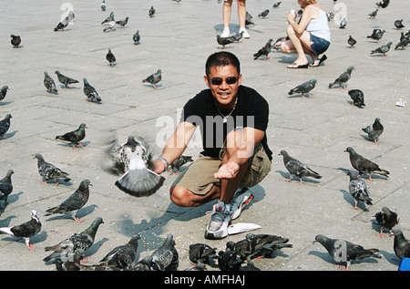 Alimentation tourisme pigeons, Piazza San Marco, la Place Saint Marc, Venise, Italie Banque D'Images