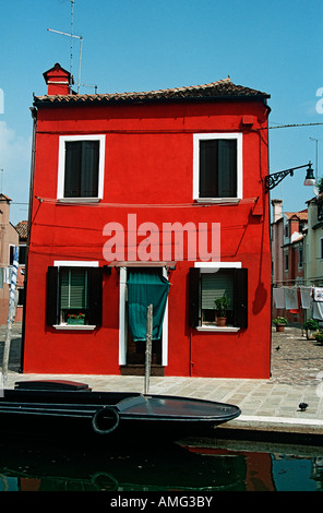 Maison rouge, typique de l'île de Burano, à côté d'un canal, Burano, Venise, Italie Banque D'Images