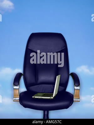 Un ordinateur portable sur une chaise de bureau contre un fond de ciel bleu Banque D'Images