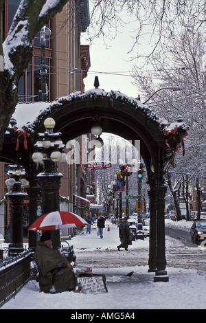 Neige de l'hiver dans la région de Pioneer Square où se trouve l'homme sans-abri avec parapluie Seattle Washington Banque D'Images