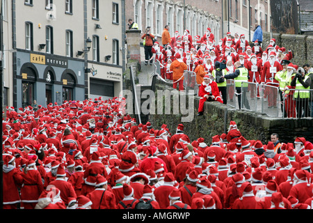 Plus de 10 000 personnes habillées en père Noël tenter le record mondial Guinness à marcher le long des murs de Derrys Irlande du Nord Banque D'Images