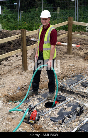 Workman éliminer l'eau de recyclage d'eau de pluie sur l'unité de développement de la propriété nouvelle Banque D'Images