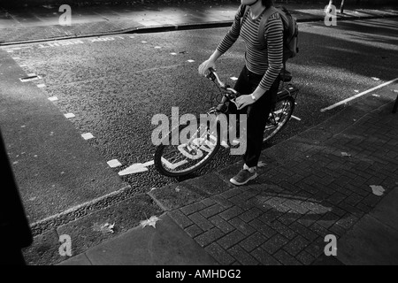 Femme sur rue avec vélo, Londres, Angleterre Banque D'Images