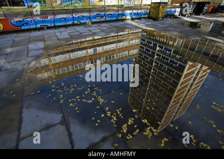 Un reflet dans une flaque d'un bloc d'appartements à Hoxton, East London Banque D'Images