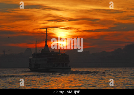 ISTANBUL, TURQUIE. Un traversier sur le Bosphore silhouetté contre un automne lever du soleil. L'année 2007. Banque D'Images