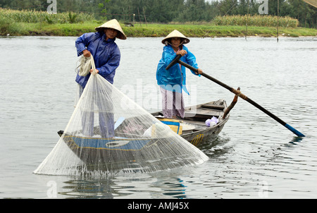Deux personnes âgées des pêcheuses mis dans leur filet pour attraper le chec kthe, Hoi An, Vietnam Banque D'Images