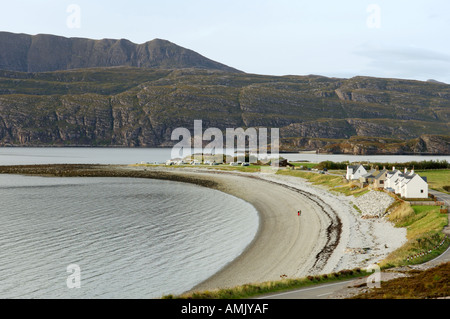 Ardmair village près d'Ullapool, Wester Ross, Scotland. Couple sur une plage de galets. Maisons de vacances. Barrière de défense de l'érosion côtière. Banque D'Images
