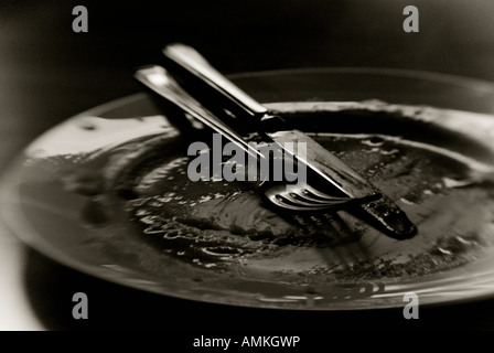 Image en noir et blanc d'une assiette vide et couverts Banque D'Images