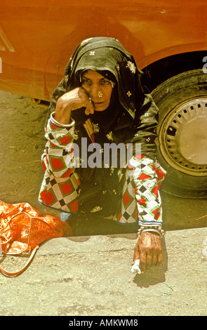 Triste Vieille Femme accroupis dans le souk de Mutrah, Oman Banque D'Images