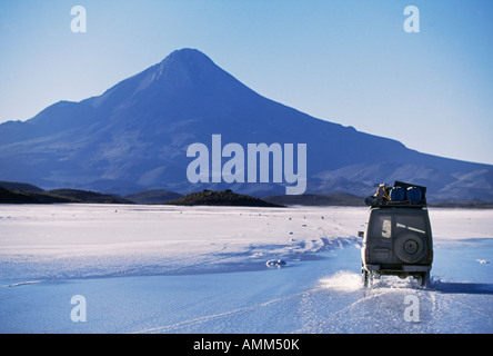 Un véhicule de tourisme à travers l'eau de surface située au-dessus de la croûte de sel sur le Salar de Coipasa Banque D'Images