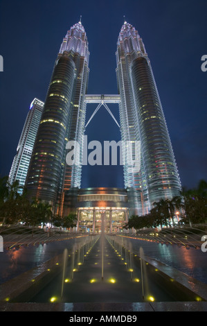 1242 Les tours jumelles de Kuala Lumpur au crépuscule avec une fontaine ornementale à l'avant-plan. Banque D'Images
