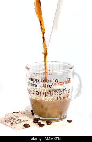 Le café et le lait sont versé dans une tasse à café en verre transparent isolé sur fond blanc Banque D'Images