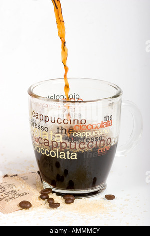 Le café est versé dans une tasse à café en verre transparent isolé sur fond blanc Banque D'Images