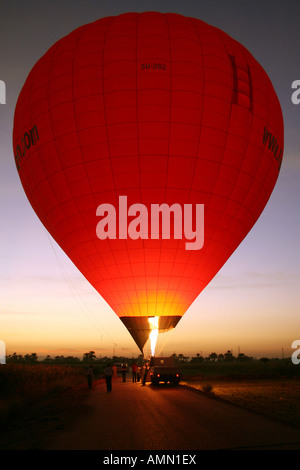 Hot Air Balloon tirant au coucher du soleil avant de soulever l'[Nil, près de Louxor, Egypte, Etats arabes, l'Afrique]. . Banque D'Images