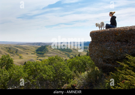 Femme et chien assis sur le bord de la Falaise Banque D'Images