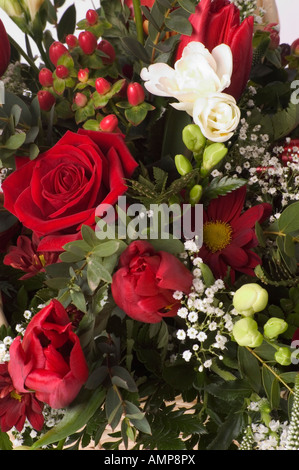 Bouquet de roses rouges, fleurs blanches, des anges, des cheveux et un assortiment de verdure Banque D'Images
