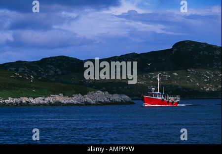Pêcheur dans un petit bateau près de Kallin harbour, Grimsay, Hébrides extérieures, en Écosse, au Royaume-Uni. Banque D'Images