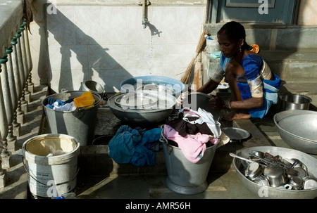 Un Indien dame lave la vaisselle et des vêtements à son domicile à Cité, Gujarat, Inde, Asie Banque D'Images