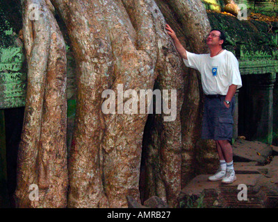 Examine l'arbre géant de fluage plus de racines demeure non restauré Ta Prohm temple Angkor Cambodge Banque D'Images