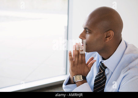 African businessman resting chin on hands Banque D'Images