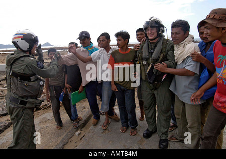 US Navy Le Capt Matt Klunder gauche et maître de 2e classe Donal Shannon sont a remercié par des habitants après le déchargement de la supplie de secours Banque D'Images