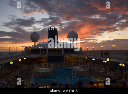 En regardant vers l'arrière sur le plateau supérieur du paquebot de croisière tout en mer avec coucher de soleil colorés de l'océan Pacifique tropical Banque D'Images