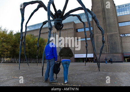 Les visiteurs Voir la sculpture en bronze Maman par Louise Bourgeois en dehors de la Tate Modern, Londres, Angleterre. Banque D'Images
