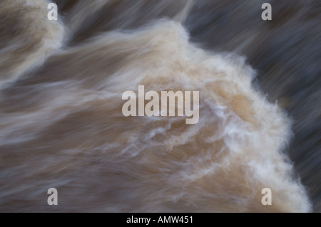 Couleur de l'eau par de la terre végétale et de la tourbe s'écoule à partir de terrains marécageux dans Slitrig à brûler à Hawick Borders écossais mouvement fluide Banque D'Images