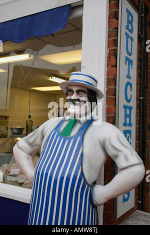 Modèle Taille de la vie d'un boucher sur le pas de sa boutique. Banque D'Images