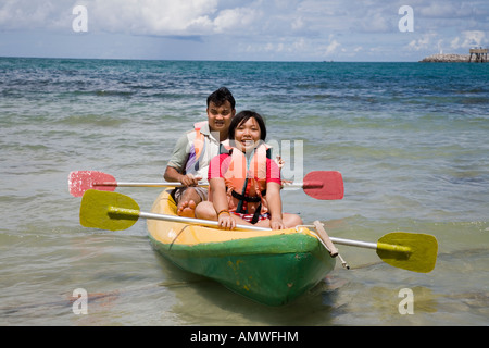 Holiday makers pagayer canoë kayak bateau sur la plage de Sattahip près de Rayong, Thaïlande Banque D'Images