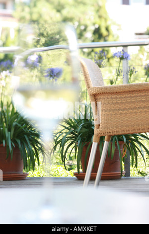 Verre d'eau avec wicker chair en arrière-plan Banque D'Images