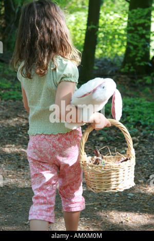 Vue arrière du girl réalisation lapin de Pâques et panier Banque D'Images