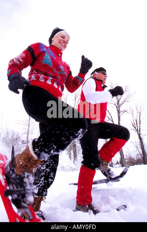 A senior couple courir en raquettes sur une sortie d'hiver Banque D'Images