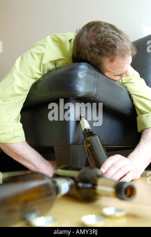 Drunken man lying on sofa Banque D'Images