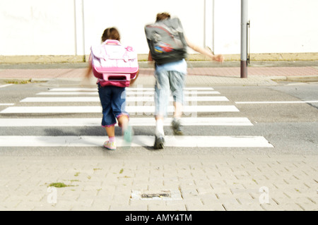 Vue arrière du garçon et fille zebra crossing Banque D'Images