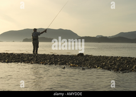 Pêche à la mouche l'homme rive de la baie Sitka SE AK de l'été près de Harbour Pt Silhouette Banque D'Images