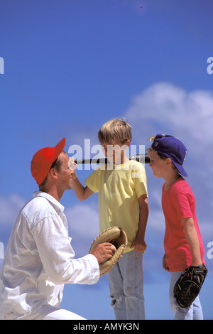 USA, Hawaii. Père d'enseigner aux enfants le baseball Banque D'Images