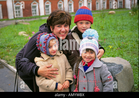 Trois jolies jeunes enfants russes avec leur mère dans la cour d'une ancienne église orthodoxe russe Banque D'Images