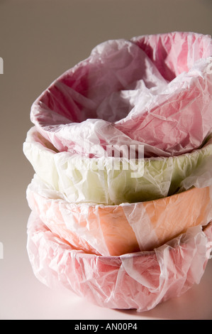 Ensemble de papier mâché bols multicolores, enveloppé dans du papier de soie blanc pour un cadeau. Tourné sur un fond blanc. Banque D'Images