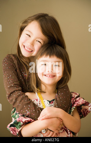 Portrait of Asian sisters hugging Banque D'Images